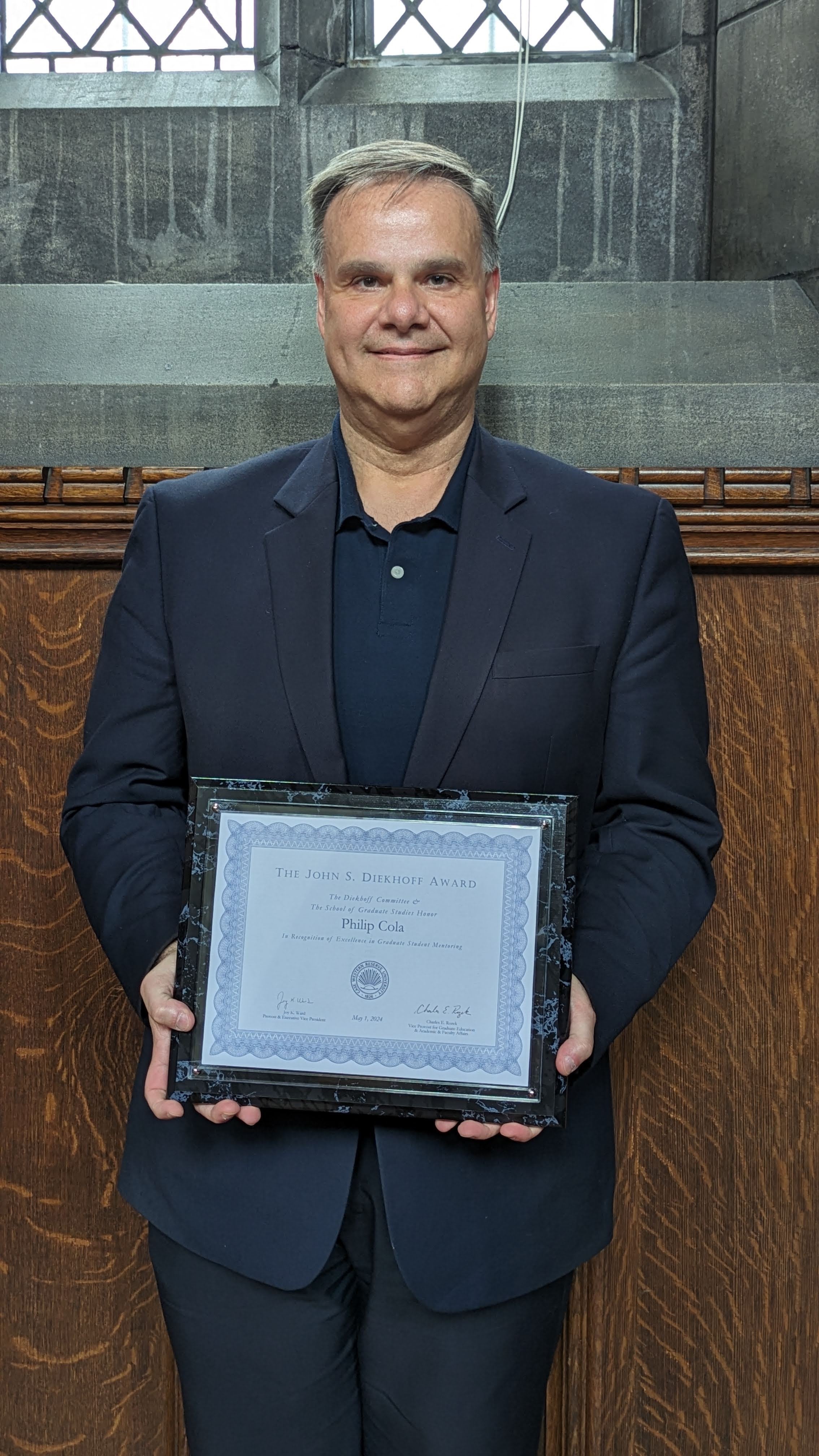 Phil Cola holding Diekhoff plaque