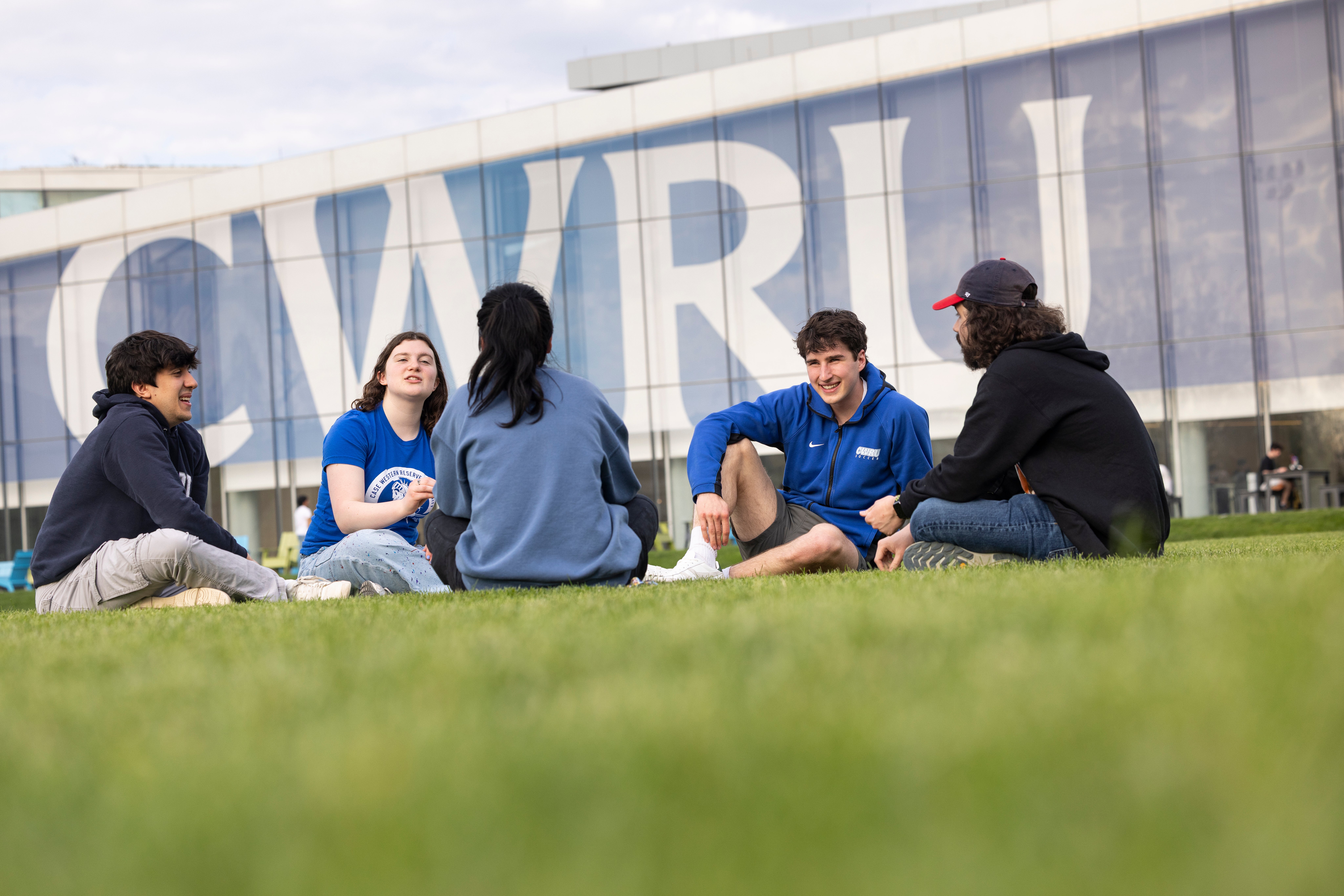 group of students sitting and talking in front of Tinkham Veale University Center
