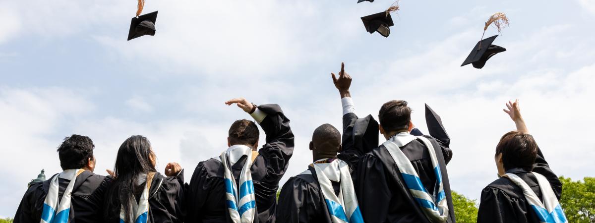 students toss graduation caps