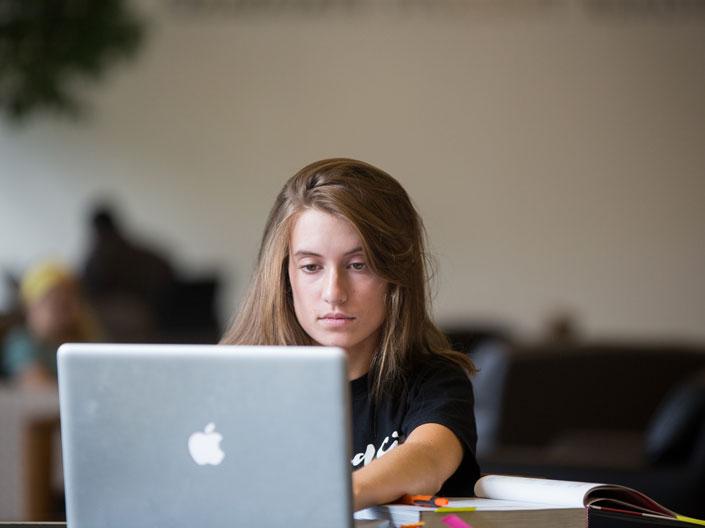 Photo of a female Case Western Reserve University student working on a computer
