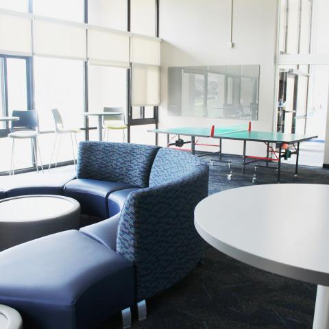 Clarke Tower Lounge with couches, coffee tables, and ping pong table