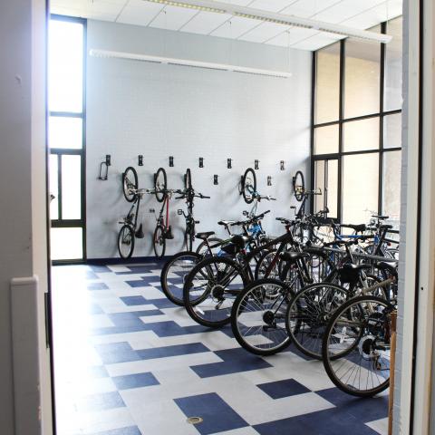 Clarke Tower 1st Floor Bike Storage with wall-mounted hooks, bike racks, and several bikes