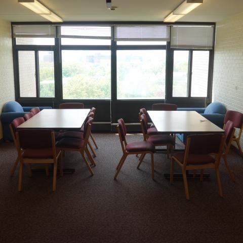 Clarke Tower Upper Floor Lounge with six-foot tables, chairs, and whiteboards
