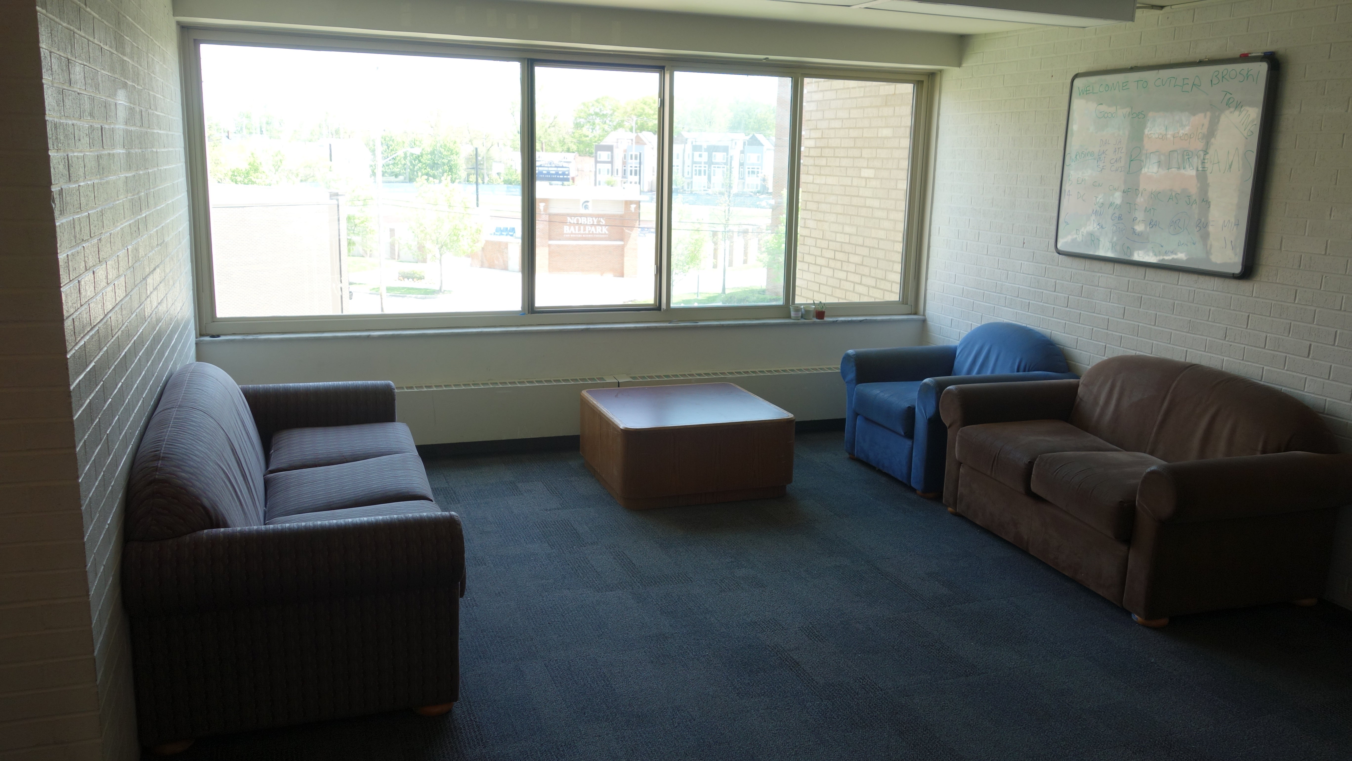 Cutler House Upper Floor Lounges with couches, coffee table, and white board