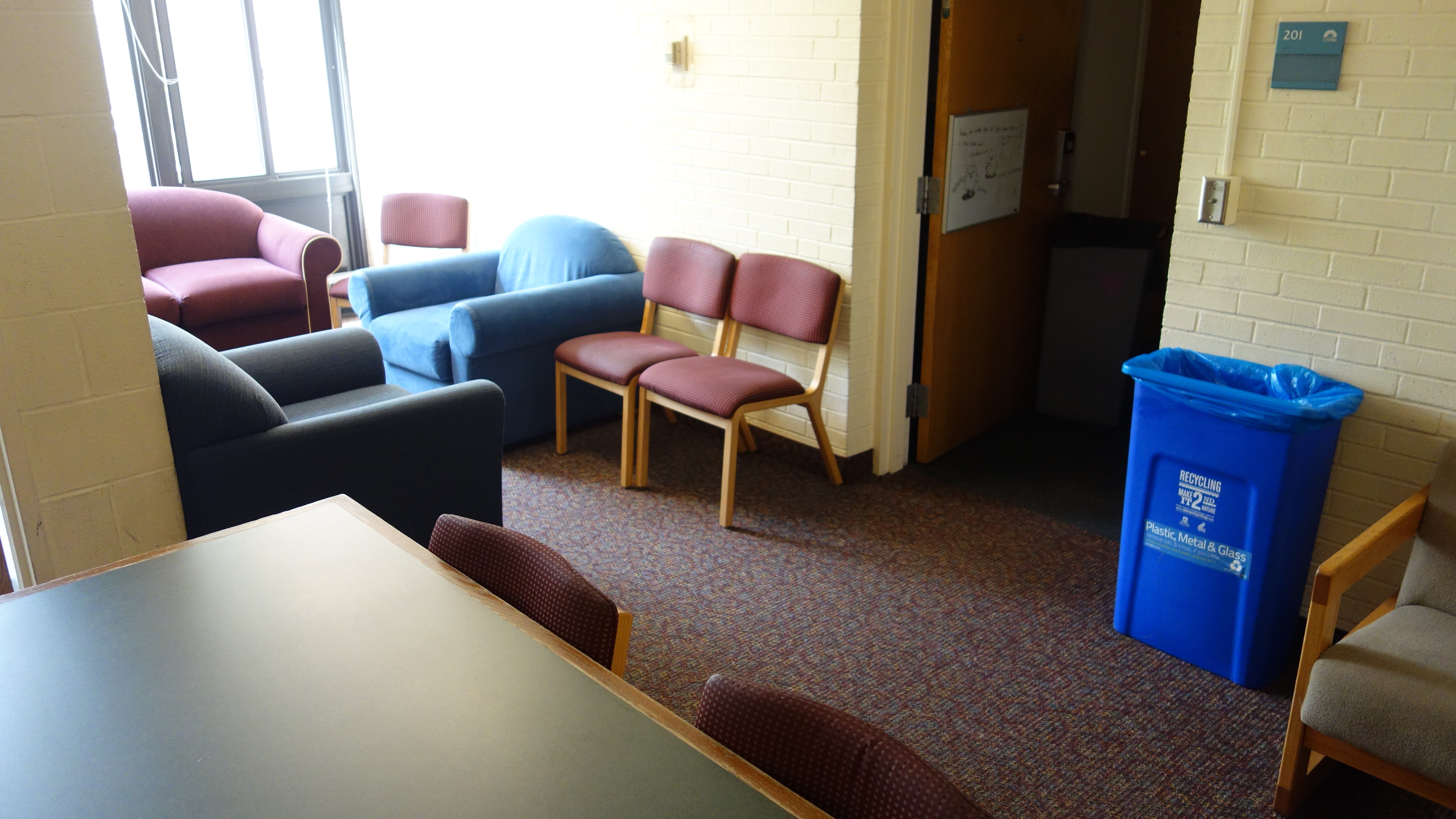 Clarke Tower 2nd Floor Lounge with tables, furniture, showing suite door open