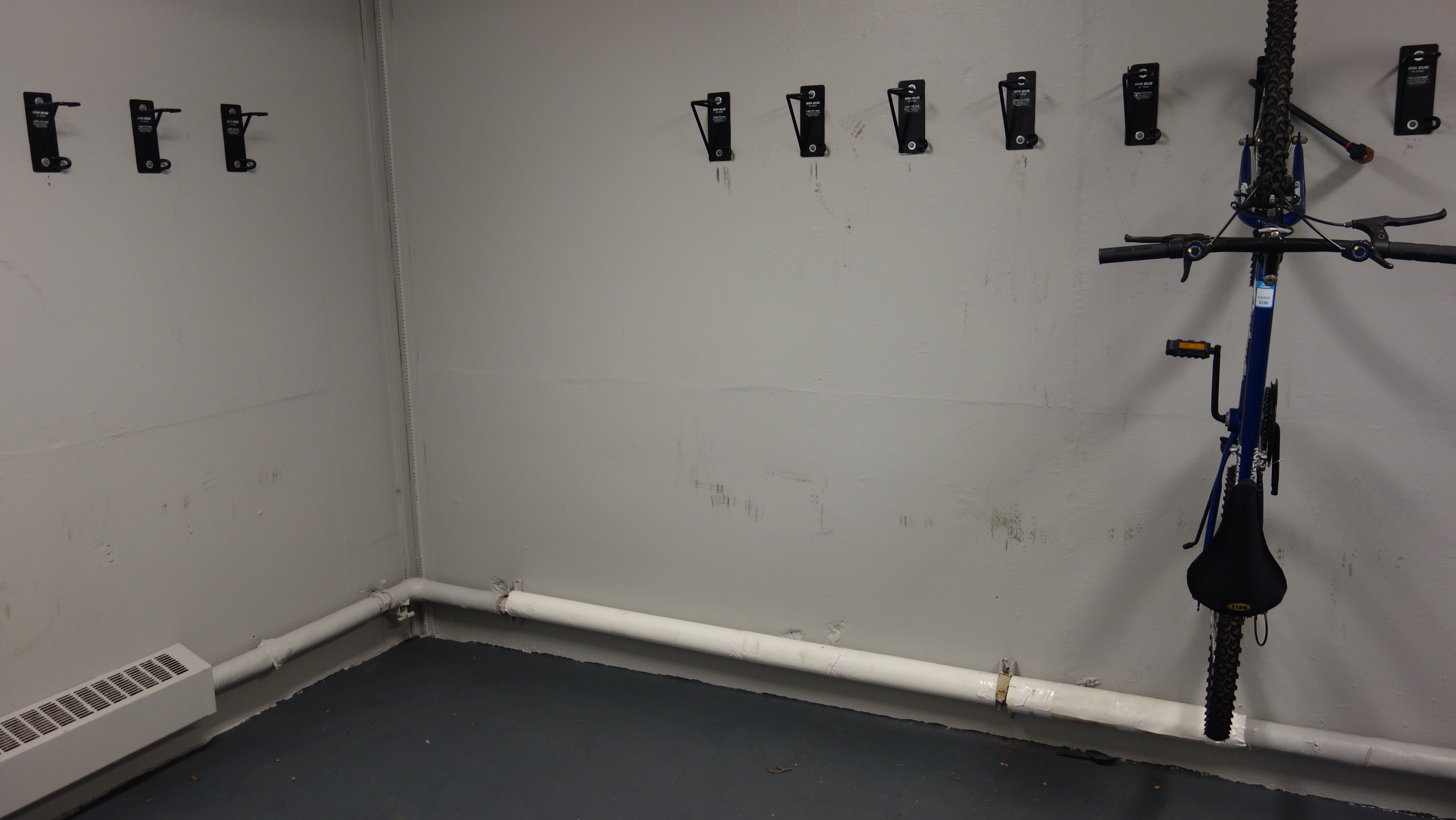 Kusch House Basement Bike Storage showing wall-mounted hooks and one hanging bike