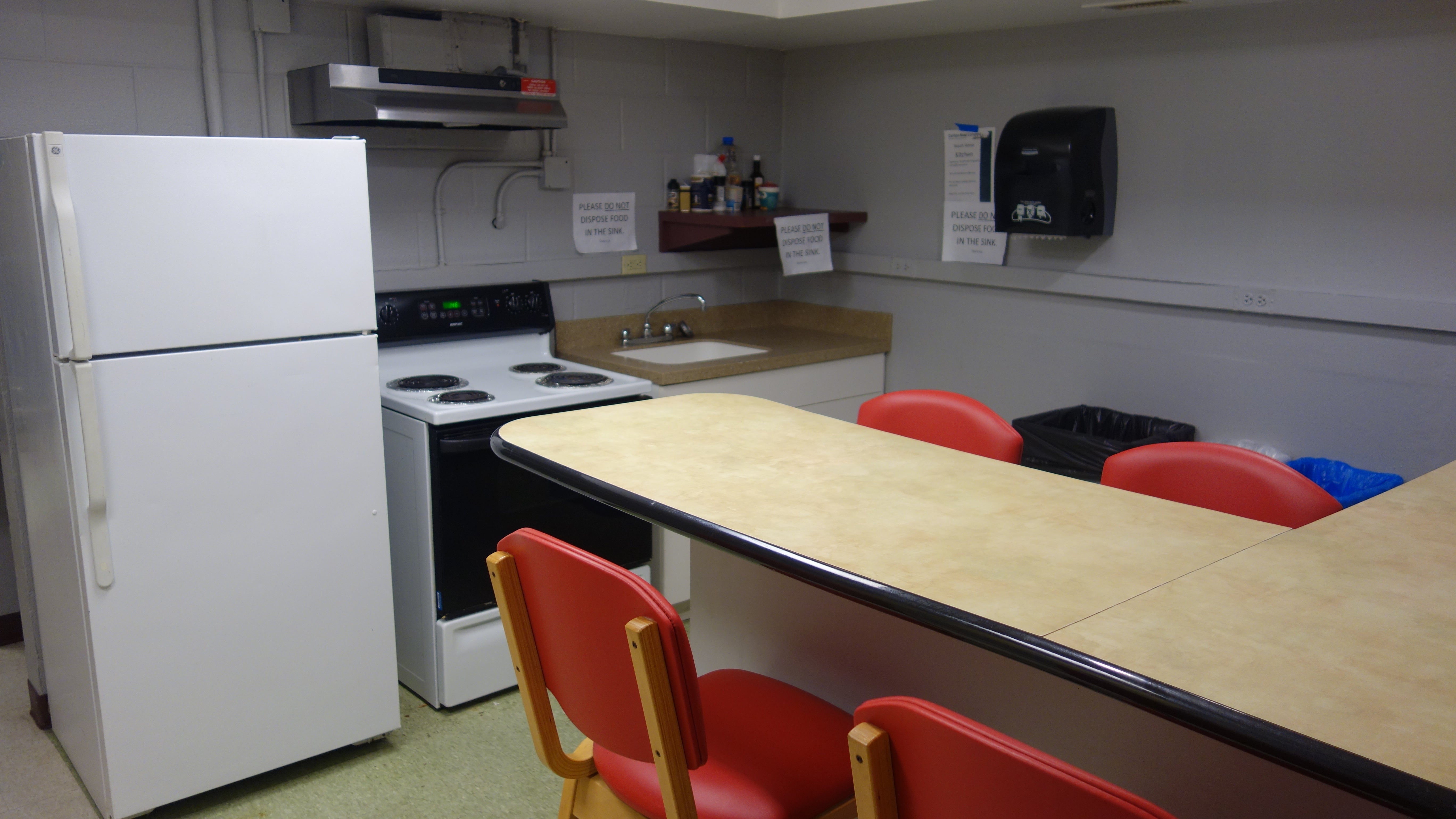 Kusch House Basement Kitchen showing counter top, bar stools, and appliances