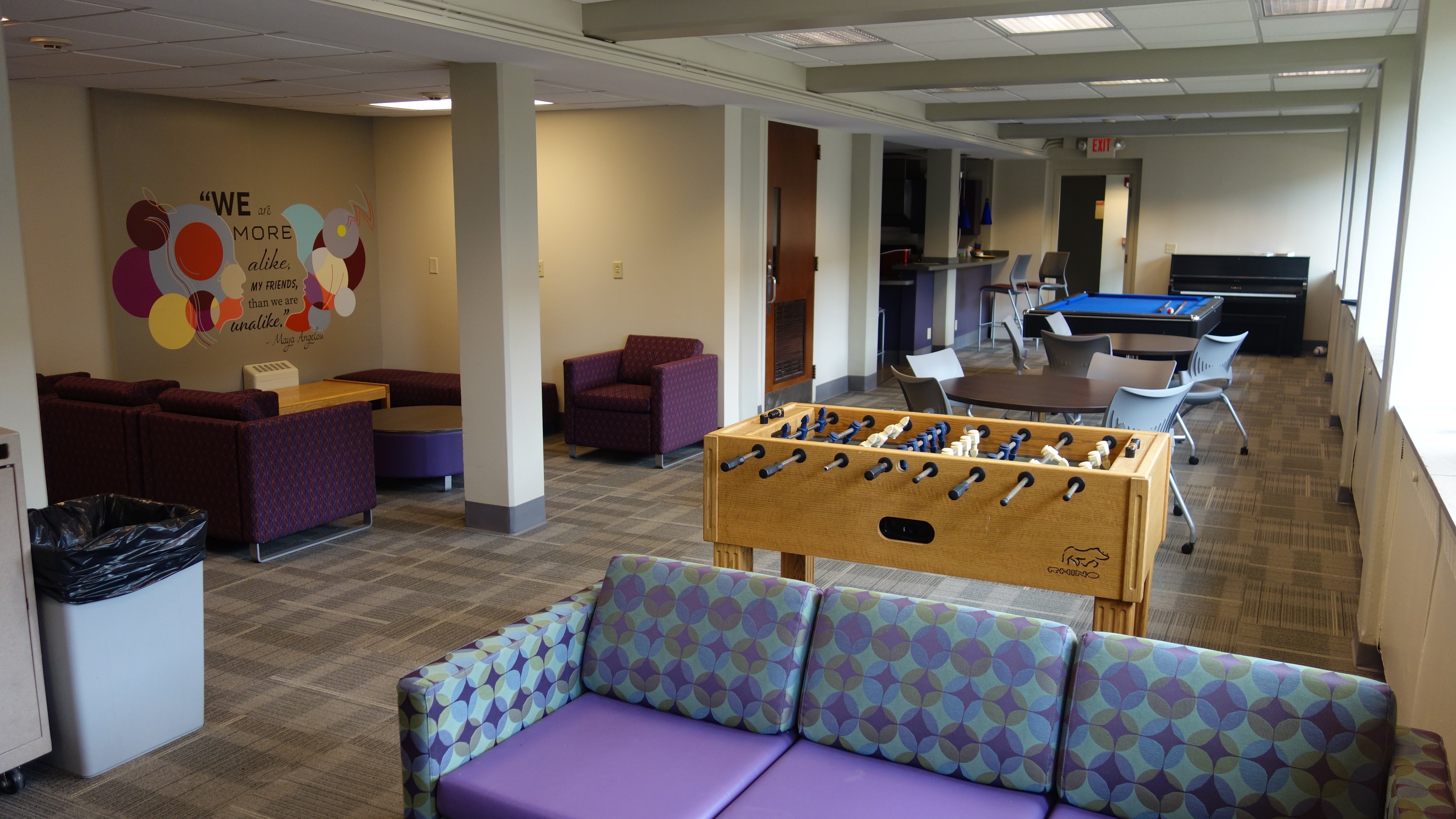 Alumni House Common Room with furniture, game tables, and mural