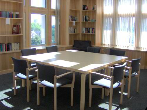 Village House 3A 5th floor library with tables, chairs, and book shelves