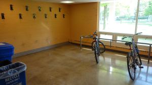 Taft House indoor bike storage space with wall-mounted hooks and ground rack