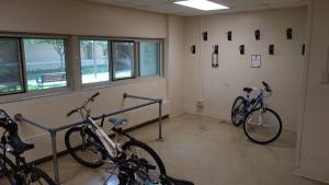 Cutler House Bike Storage Room with wall-mounted hooks, bike rack, and three bikes