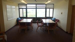 Clarke Tower Upper Floor Lounge with six-foot tables, chairs, and whiteboards