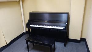Kusch House Basement Practice Room showing common piano and bench