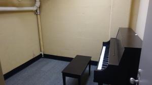 Michelson House Basement Practice Room showing common piano and bench