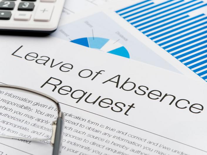 A form with the words Leave of Absence Request with a pair of glasses and a calculator