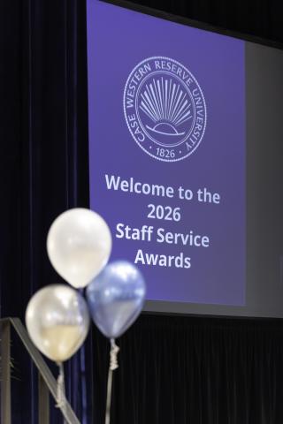 Balloons in front of a presentation slide that reads "Welcome to the 2026 Staff Service Awards"