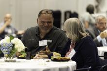 Two employees talking and smiling at each other while sitting at a decorated table