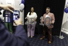 Two employees holding large numbers 25 and 10 in honor of their years of service at the university