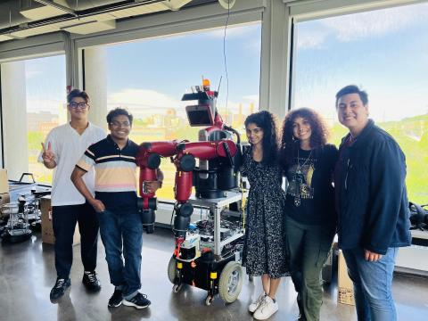 Phurinat Pinyomit, Partha Datta, Ishika Kanakath, Lana Oglesby, Noah Medrano pose with a robot