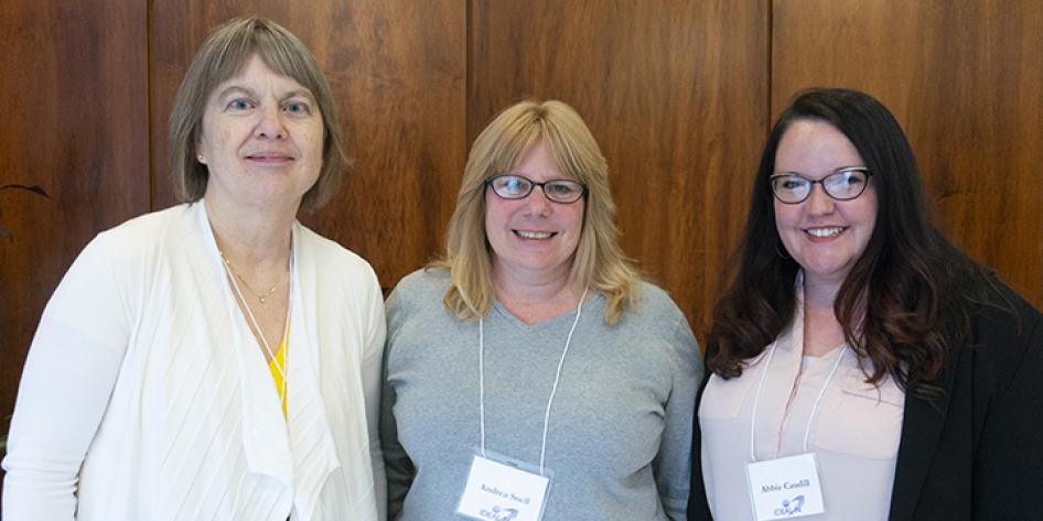 Three women smiling for a posed photo at Annual Plenary 2018
