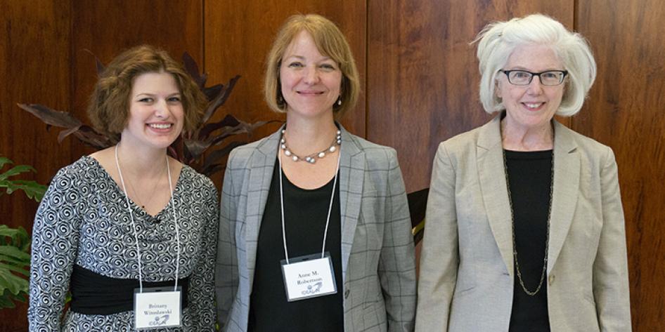 A posed photo of three women smiling at Annual Plenary 2018