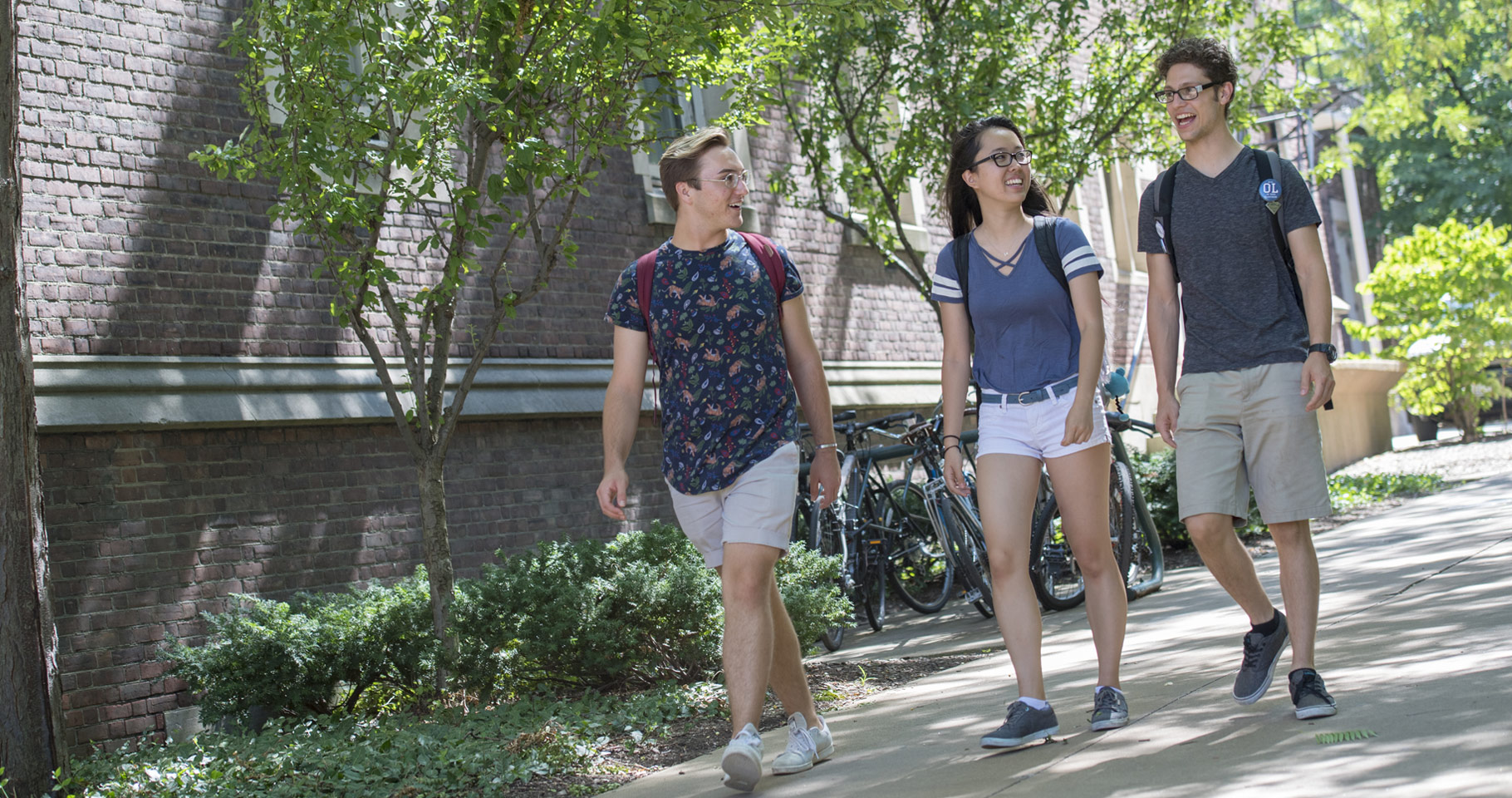 Photo of three CWRU students walking across campus and talking