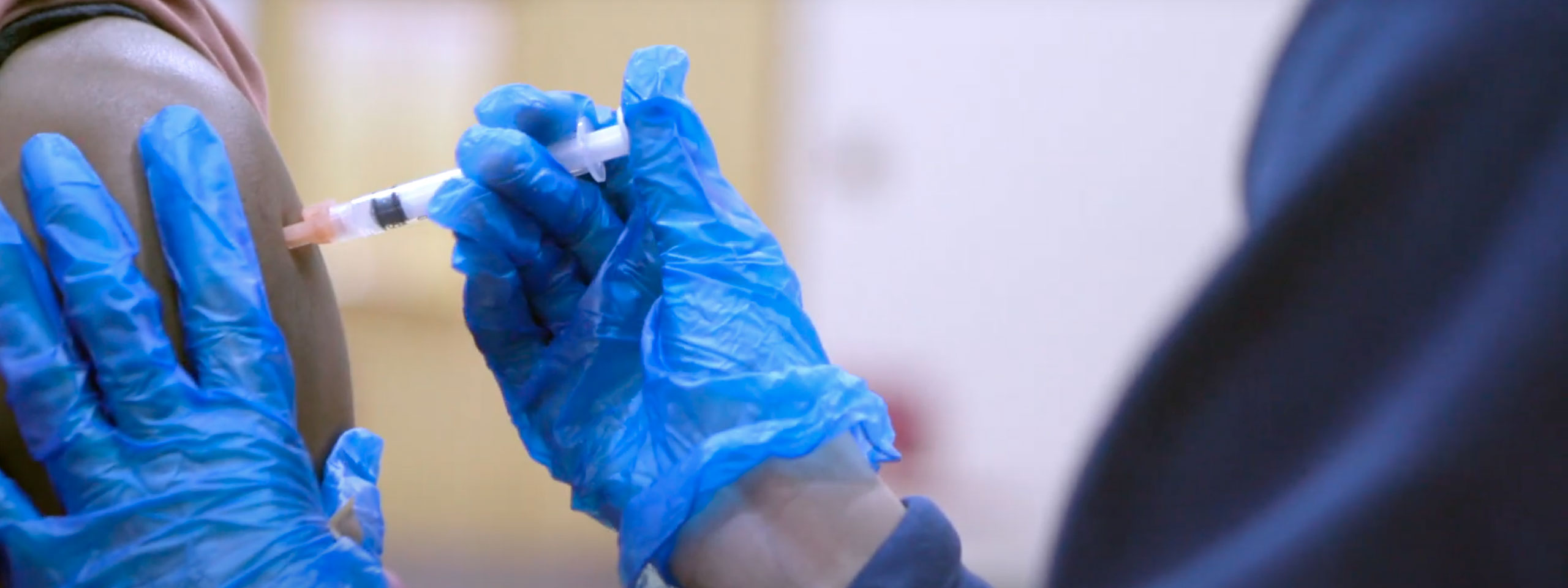 Photo of a student filling a needle from a COVID-19 vaccine vial