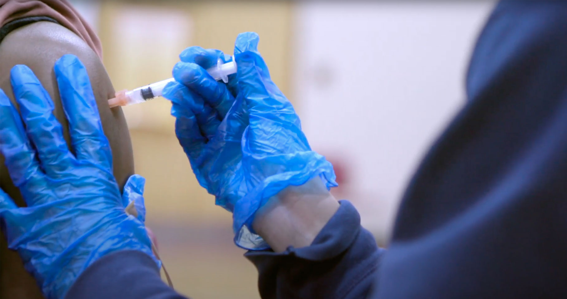 Photo of a student filling a needle from a COVID-19 vaccine vial