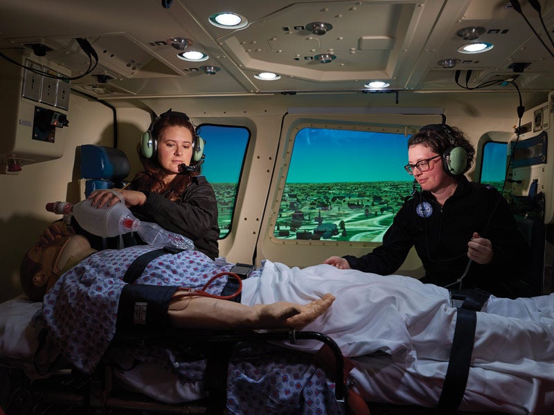 photo showing two students working in the flight nursing program simulator