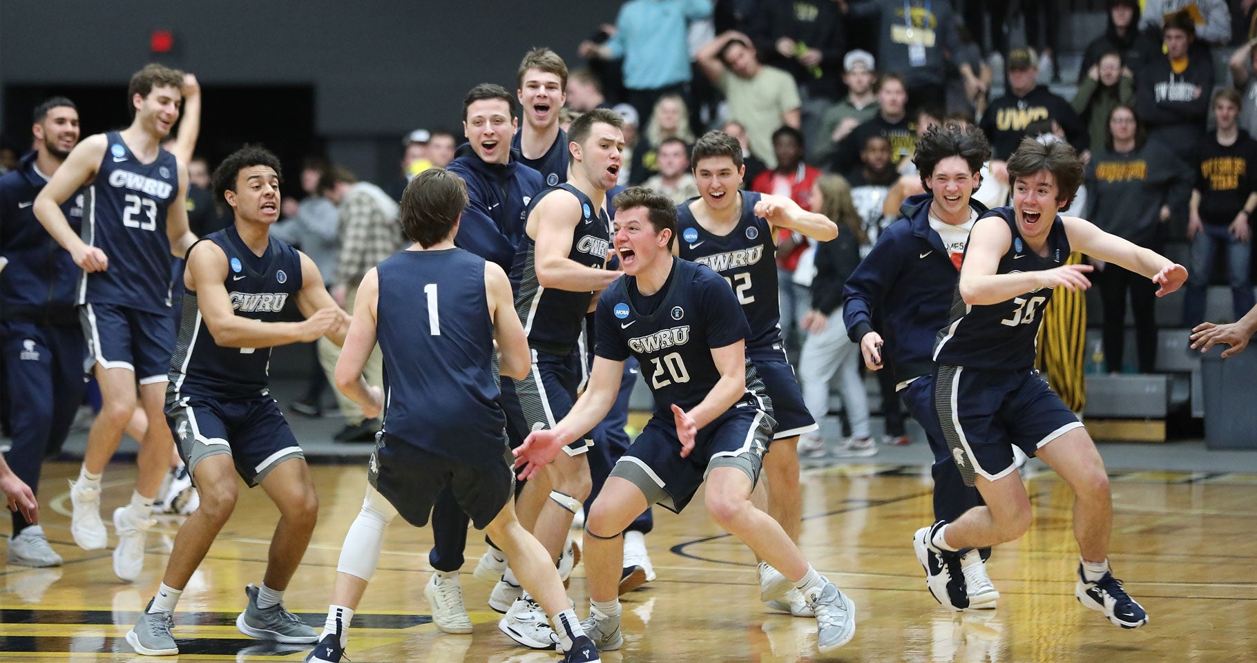 Photo of Case Western Reserve University men's basketball players cheering after a win