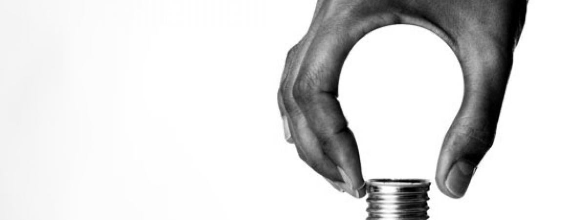 black and white picture of a hand cupping a light bulb