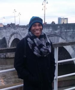 Joshua Perry stands in front of a bridge