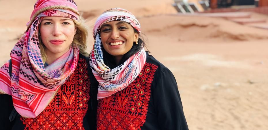 Photo of 2 Study Abroad Students in Bedouin Attire in Desert