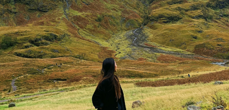 A study abroad student looks at mountains in the landscape before her