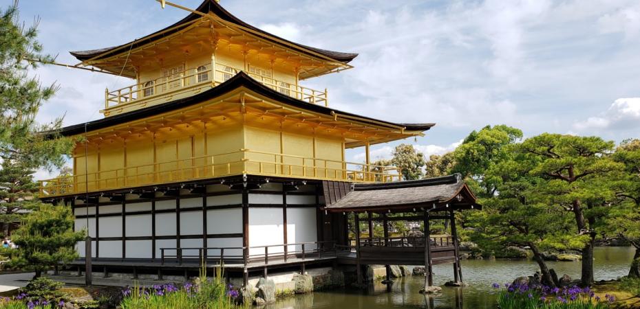 a picture of a building in japan surrounded by trees and water