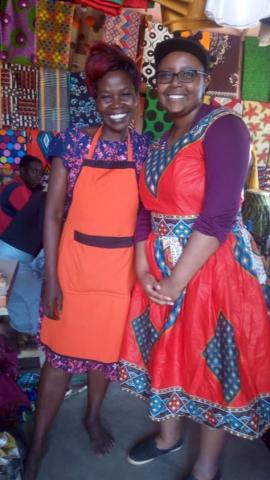 A picture of Gabrielle standing with a tailor in the Luwero District of Uganda, who altered Gabrielle’s brightly-colored dress in less than five minutes