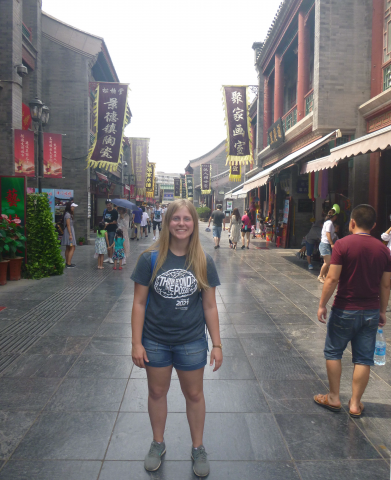 A CWRU student stands in a market in China