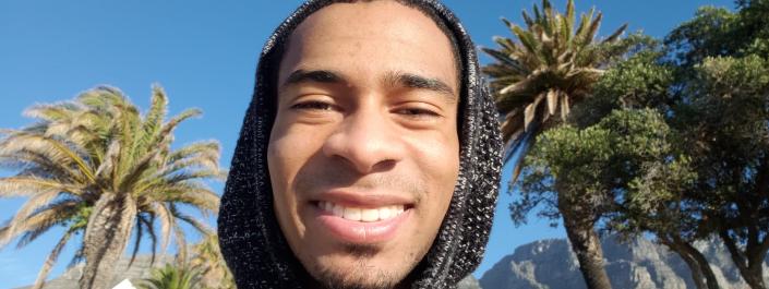 Carlos Lewis-Miller standing outside in front of palm trees