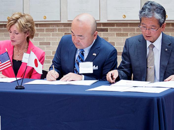 President Snyder signing paperwork with representatives from Japan