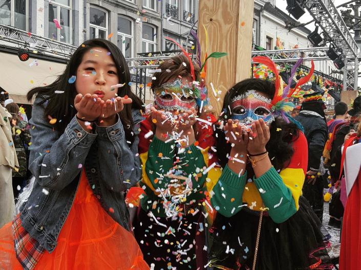 Students at carnival in Netherlands blowing confetti
