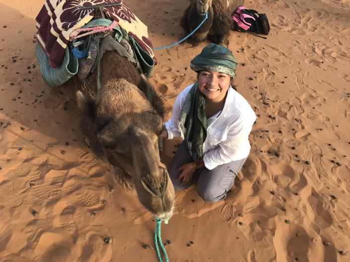 CWRU study abroad student pictured with a camel in the desert.