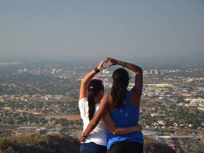 2 CWRU Students on a Hilltop looking out over a city with linked arms