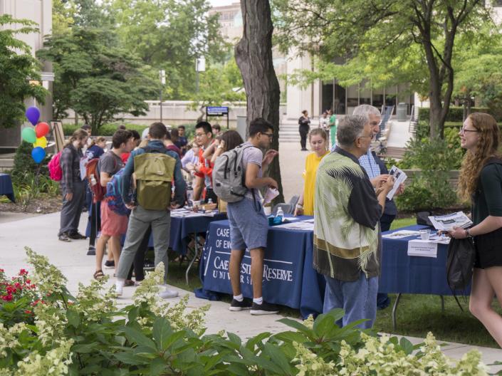A photo of students visiting information tables at the 2018 Study Abroad Fair held outside on the main quad at CWRU
