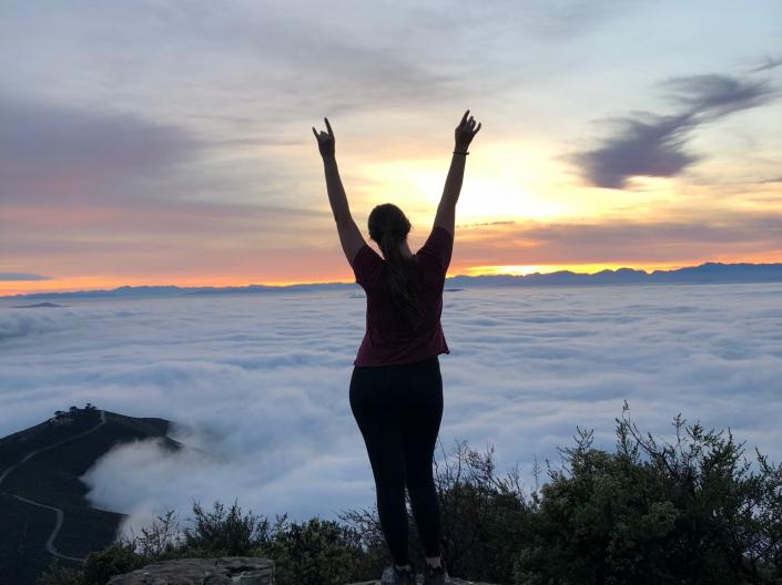 shadow of a woman with arms outstretched to the sky