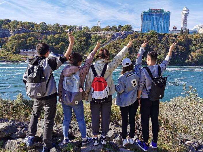 A group of CWRU international students stand looking at Niagara Falls