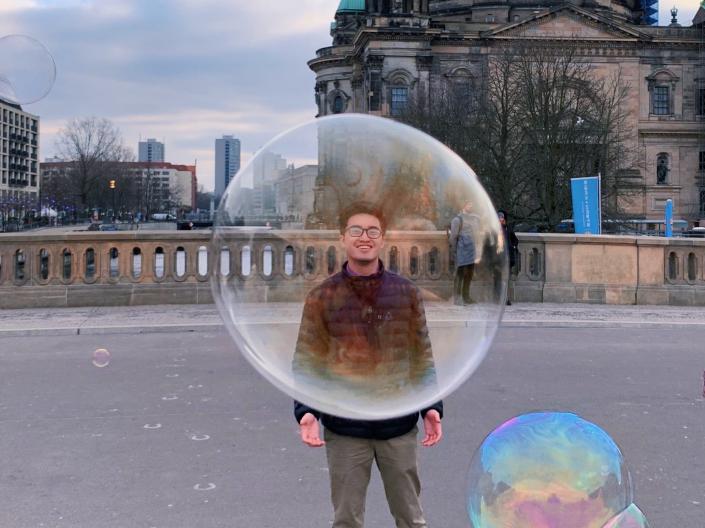 A CWRU student poses behind a bubble floating