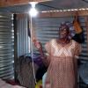 A member of the community in Namibia turns on a new light in her home