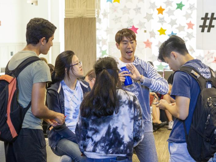 CWRU international students talking in a circle inside Tomlinson Hall