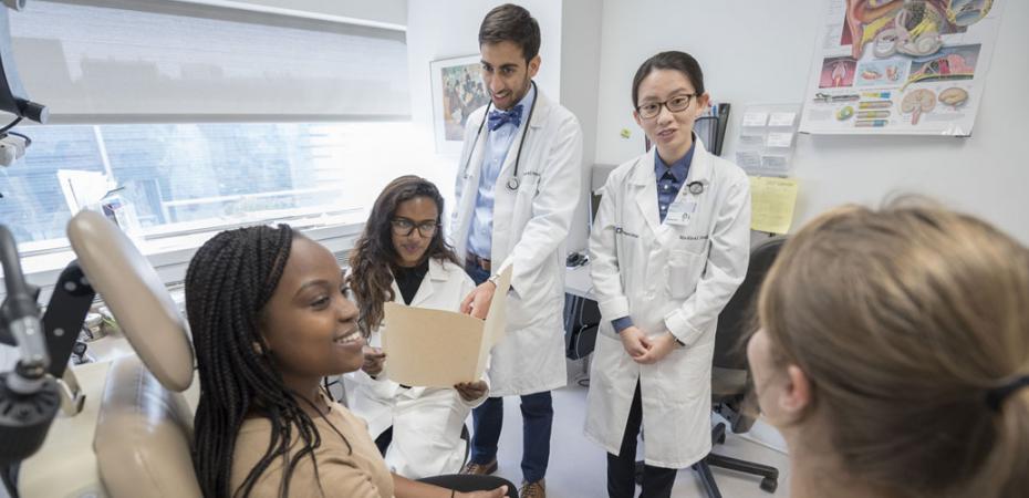 Students examining a patient during class