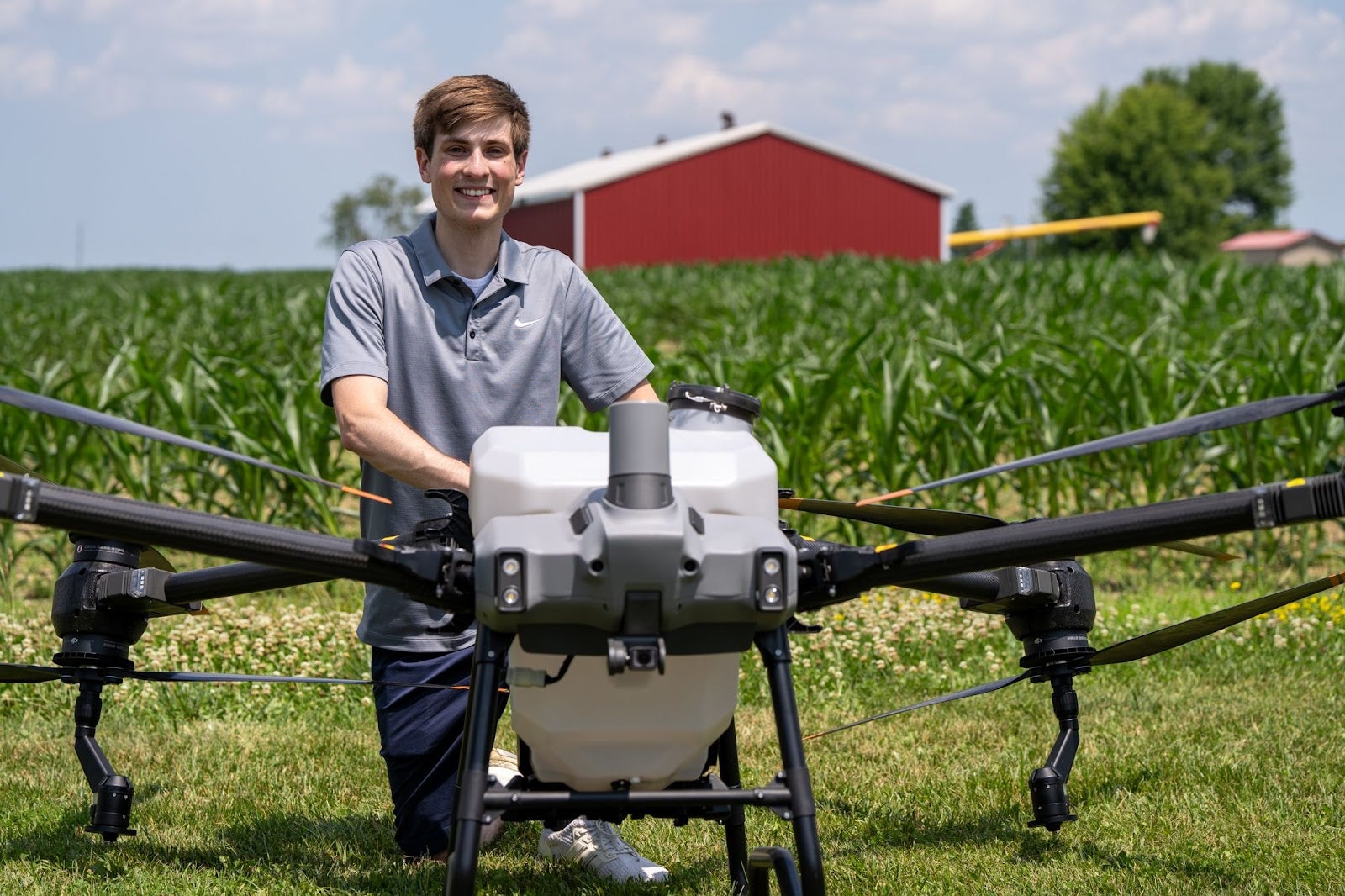 Ethan Moore in farm field next to large drone